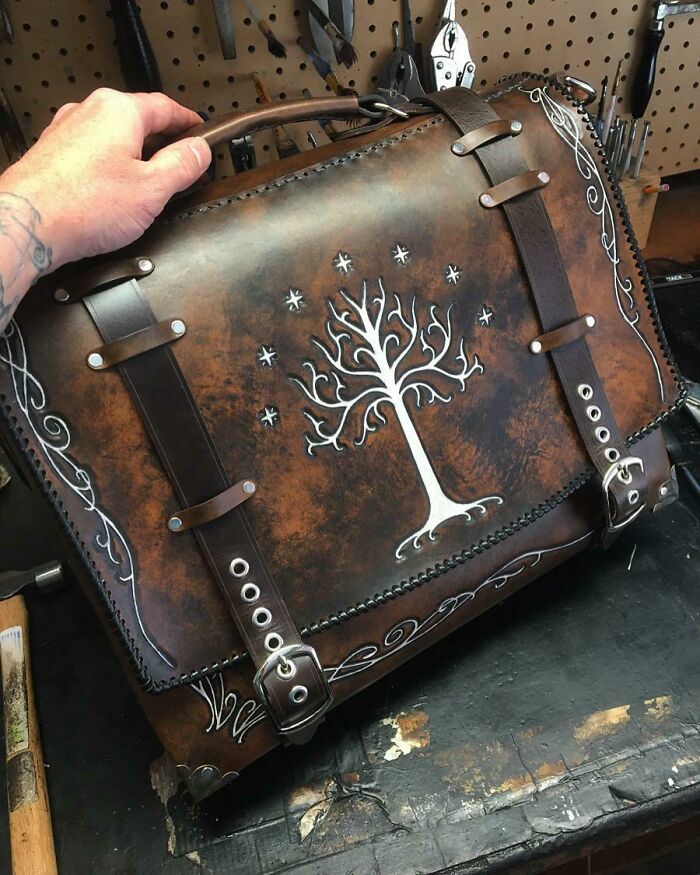 Amazing crafts: A handcrafted leather bag featuring an intricate tree design, demonstrating exquisite craftsmanship and artistry.