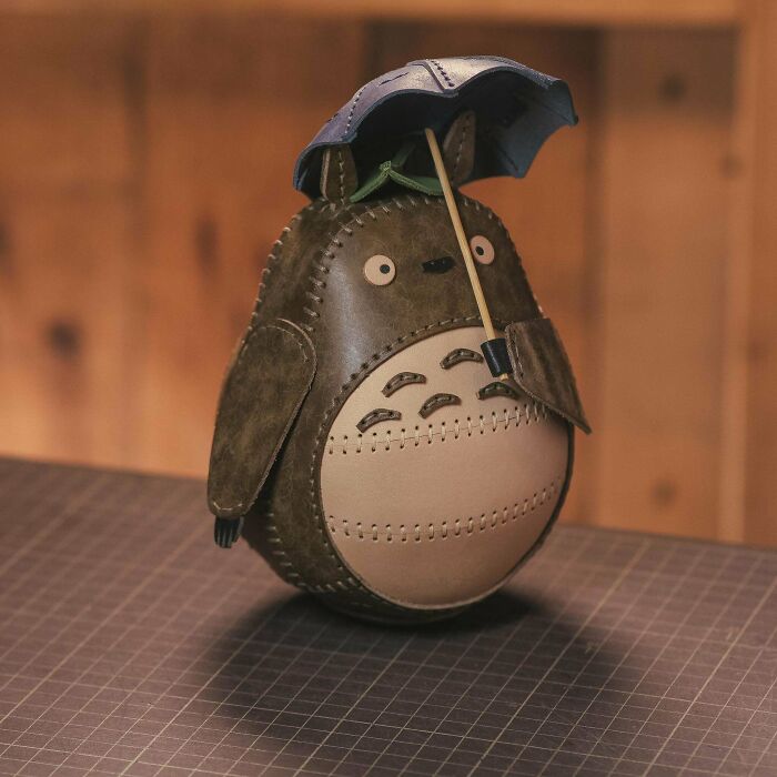 Amazing crafts: A small, detailed leather figurine of Totoro holding an umbrella, highlighting the precision of handmade crafts.