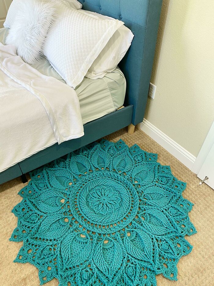 A beautiful teal crochet rug with an intricate mandala pattern, highlighting amazing crafts in home decor.