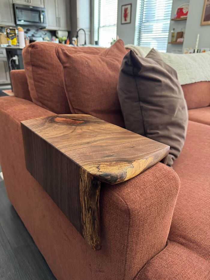A wooden armrest tray on a couch, an amazing craft that proves people can go above and beyond.