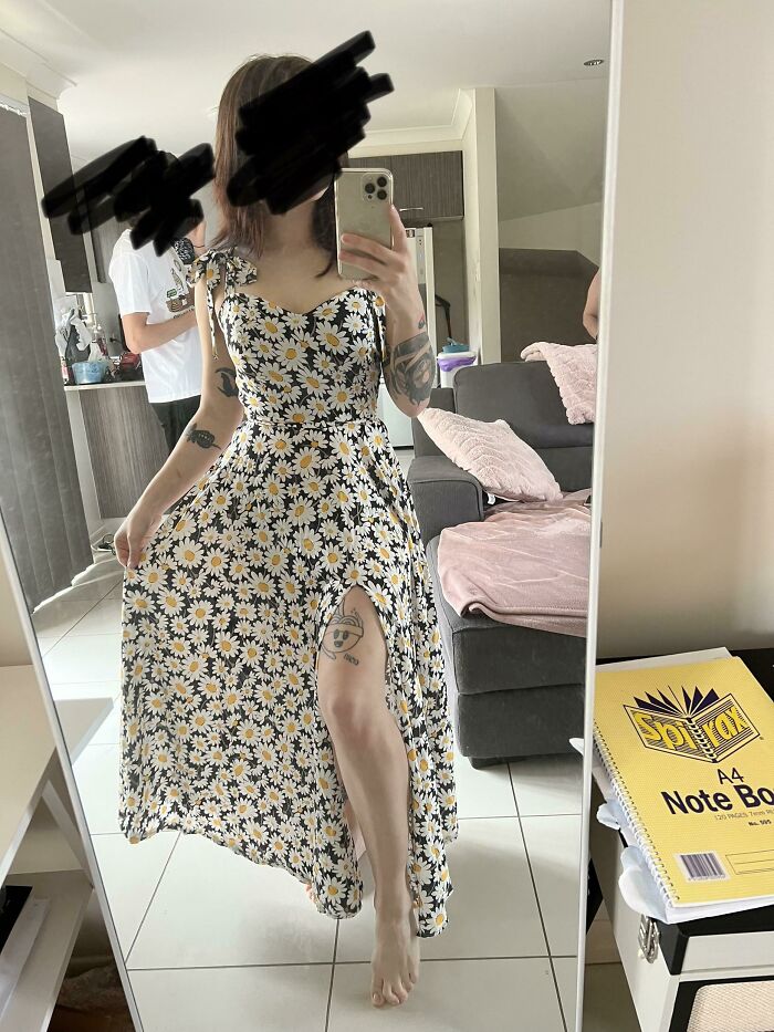 Amazing crafts: A woman in a long, floral dress with a slit, taking a mirror selfie.