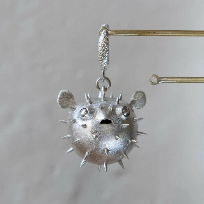 A close-up of a puffer fish-shaped earring, showcasing amazing crafts and intricate details.