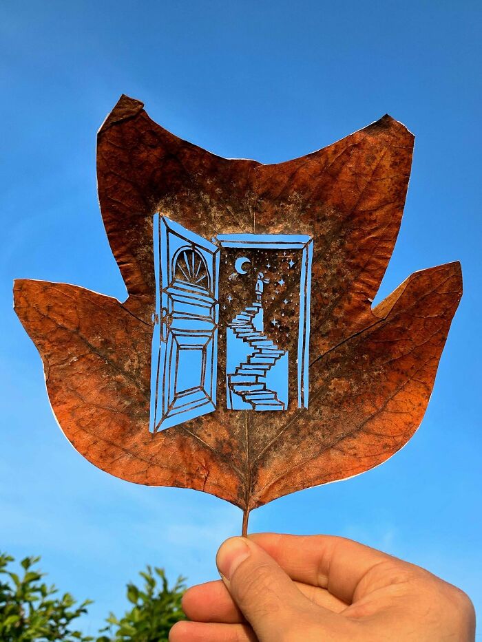 An amazing craft of a brown leaf with a detailed cut-out of a door and a spiral staircase leading to the moon.
