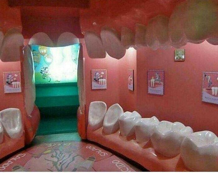 An indoor room designed like a giant mouth with large teeth, a slide in the back, an example of awful ideas.