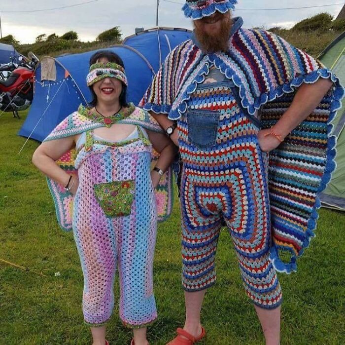 A couple dressed in brightly colored, crocheted full-body costumes with capes, showcasing awful ideas with skill.