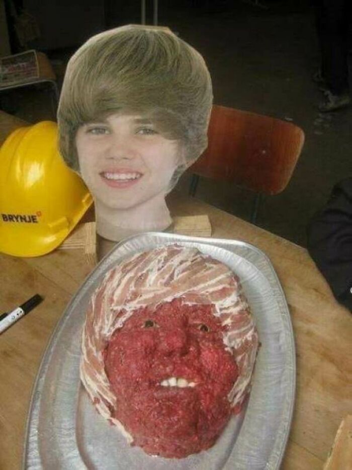 Awful idea: a disturbing Justin Bieber meat bust on a tray, executed with skill beside a cardboard cutout.