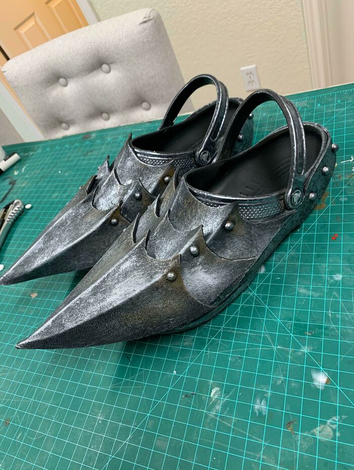 Silver crocs shaped like medieval armor, an awful idea executed with disturbing levels of skill.
