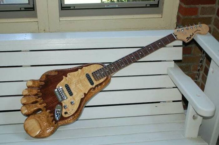 A guitar shaped like a human foot, showcasing awful ideas with disturbing levels of skill.
