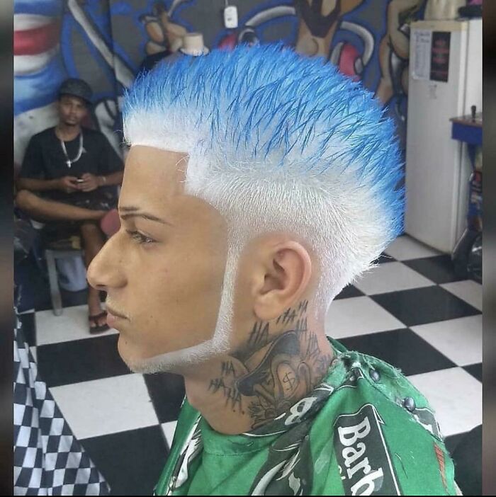 A man with a bold blue and white hairstyle, a display of awful ideas executed with disturbing levels of skill.