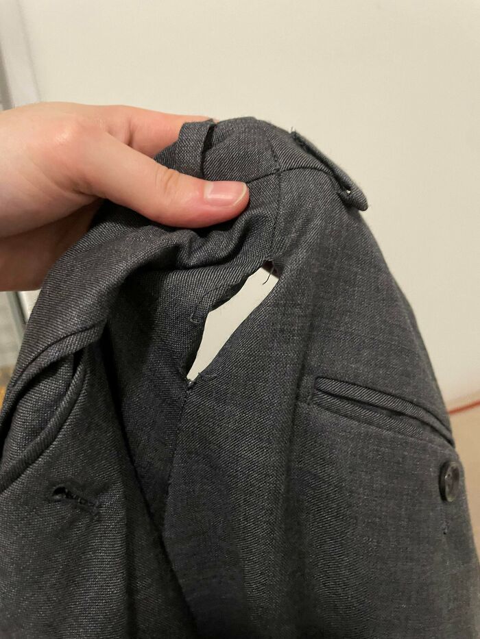 Close-up of a ripped suit jacket, showing one of the worst wedding moments guests cant believe actually happened.