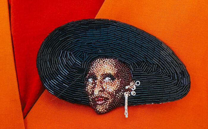 Elegant beaded creation of a woman's face with a wide hat by Tiffany Pisani, showcasing incredible beaded artwork.