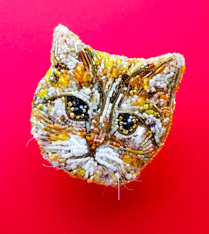 A close-up of a charming cat face, intricately crafted with colorful beaded creations by Tiffany Pisani.