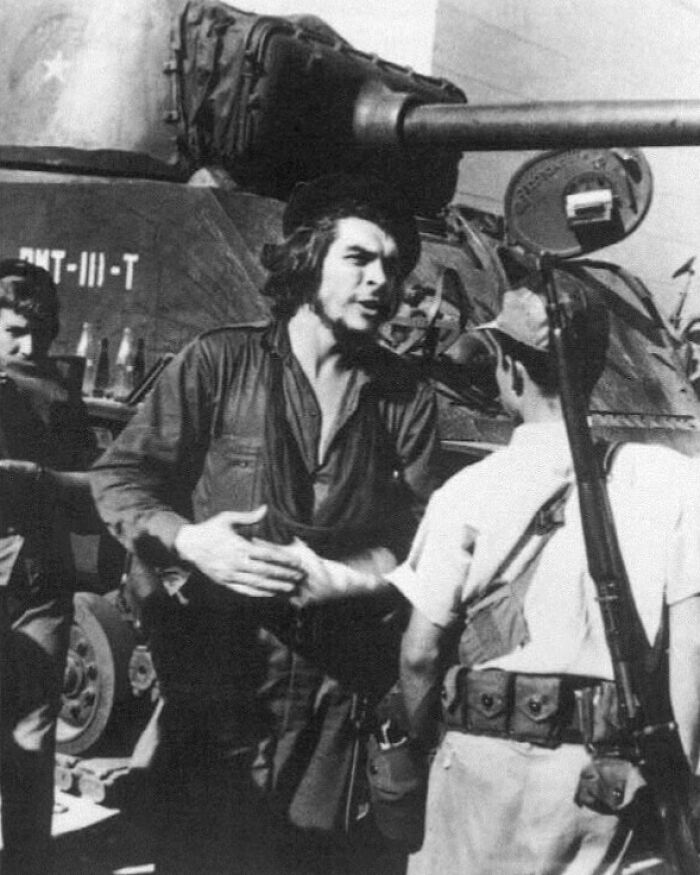 Che Guevara standing by a tank, a lost moment from history showcasing revolutionary figures.
