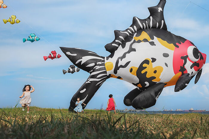Children running with giant fish kites, part of the Edge Street Photography Awards.