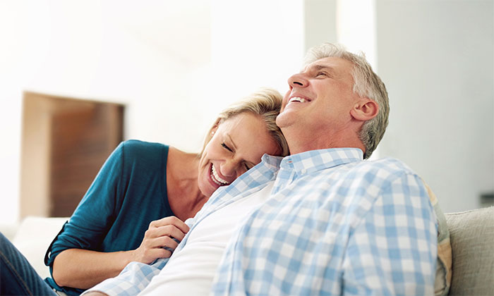 A happy couple on a couch, having found fun dinner buddies, no longer worrying about bills. A happy couple on a couch, having found fun dinner buddies, no longer worrying about bills.