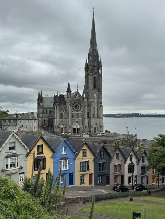 Picturesque town with a grand cathedral towering over colorful houses, epitomizing unique building character.
