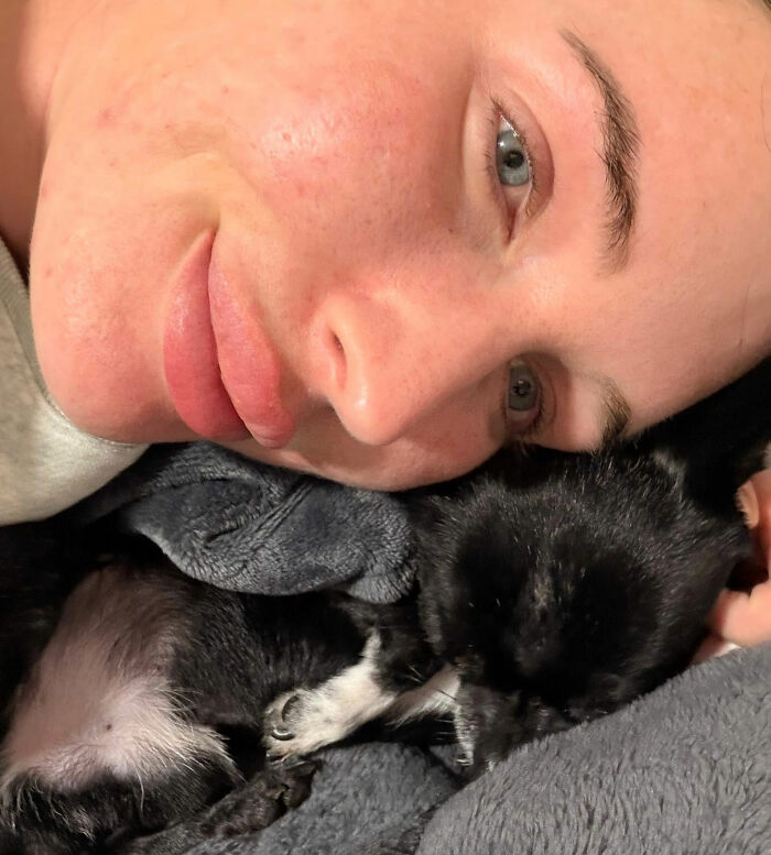 A devastated mom making new friends with a small dog, smiling and cuddling. A devastated mom making new friends with a small dog, smiling and cuddling.