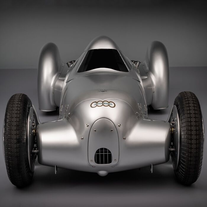 A sleek, silver vintage race car with a unique design, showcasing brilliant and beautiful design.