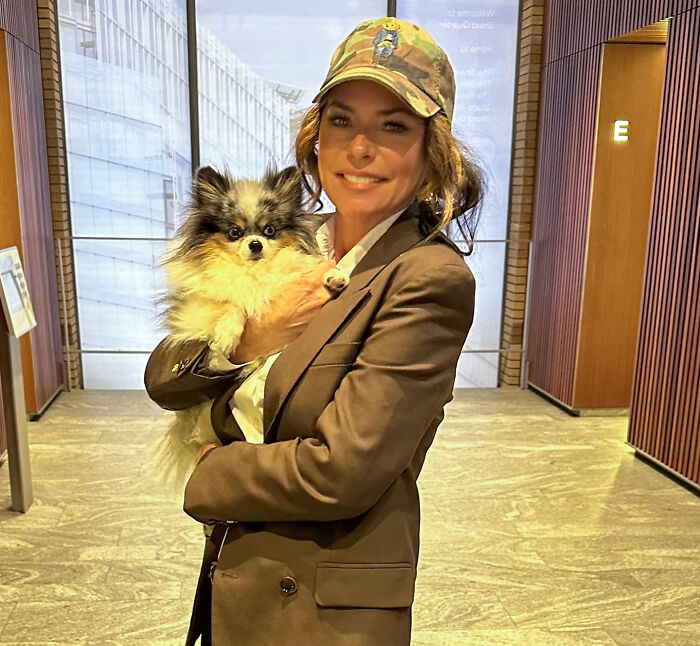 Shania Twain holding a small dog, with discussions on worst celebrities and bombshell revelations. Shania Twain holding a small dog, with discussions on worst celebrities and bombshell revelations.