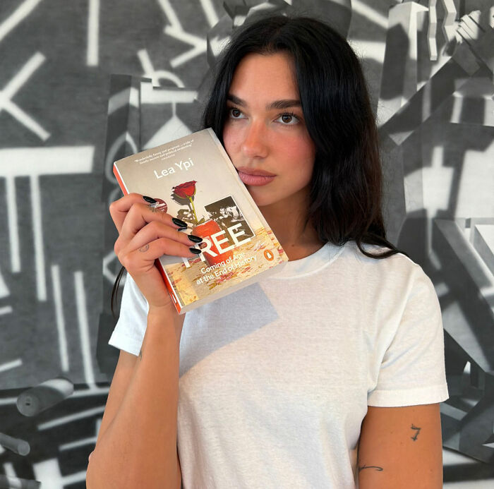 Dua Lipa holding the book Free: Coming of Age at the End of History by Lea Ypi.