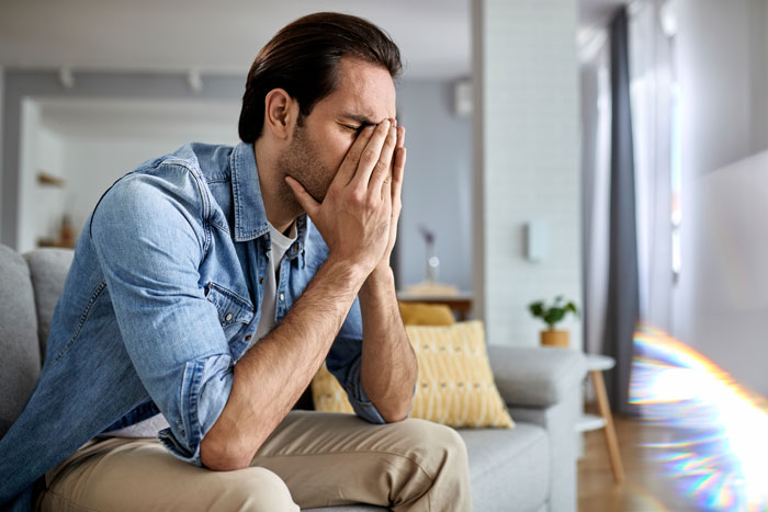 Image of a distressed man on a couch, illustrating the emotional toll of a poly wife's betrayal. Image of a distressed man on a couch, illustrating the emotional toll of a poly wife's betrayal.