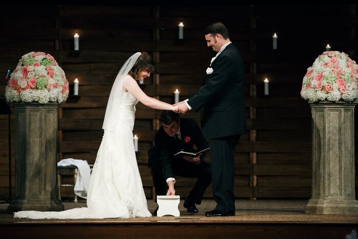 An iconic wedding photo of a bride and groom performing a unity ceremony with candles and floral arrangements.
