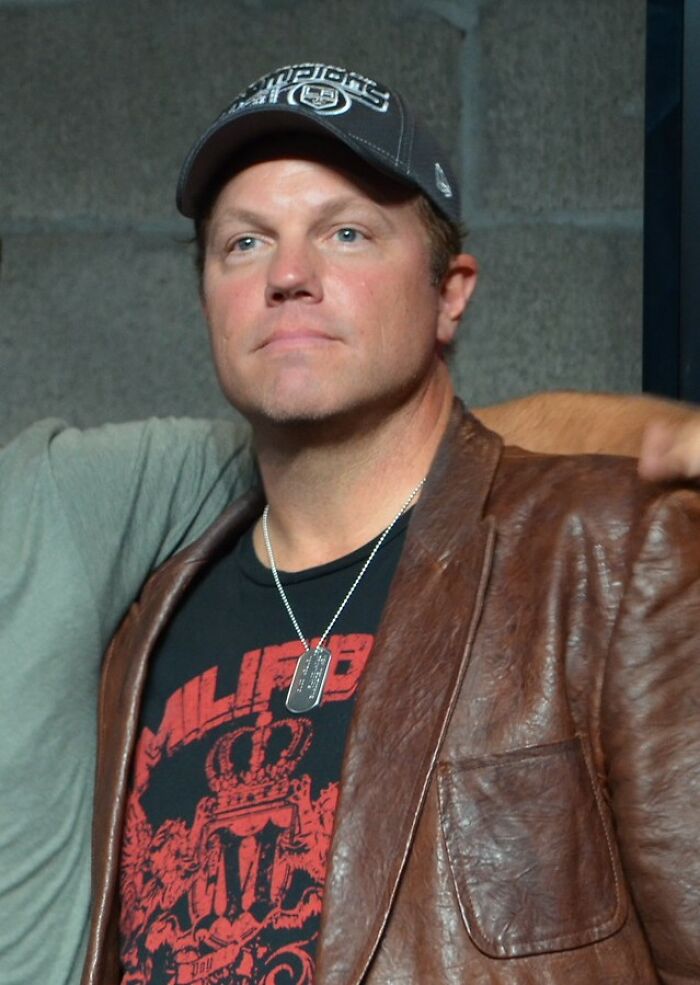 A man wearing a LA Kings cap and dog tags, reflecting on what dating a celebrity entails.
