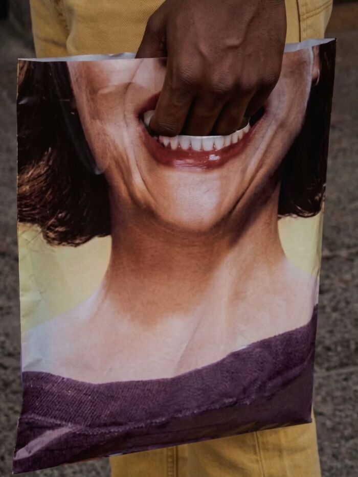 A photographer captures a funny moment of a hand reaching into a bag with a smiling face.