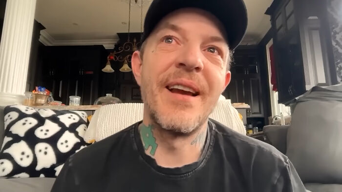 Man with tattoos and a cap looking up, revealing personal stories about dating a celebrity.
