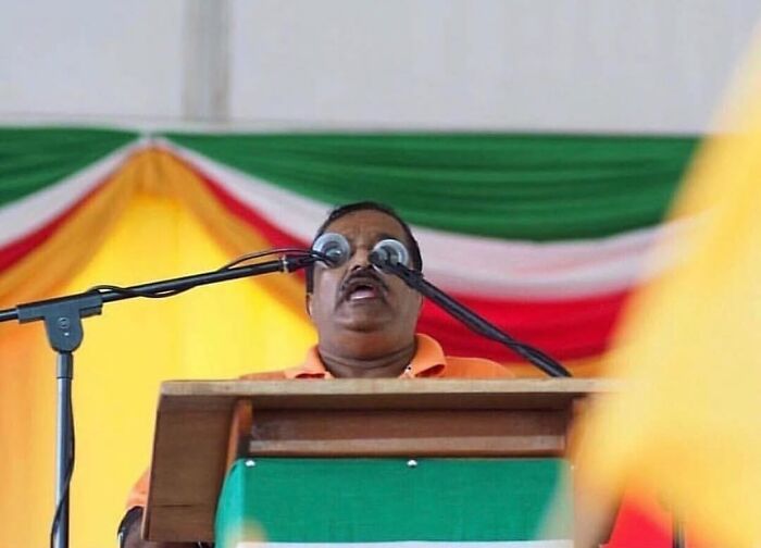 Photographers captured a speaker with microphones perfectly aligned to look like glasses, a funny moment.