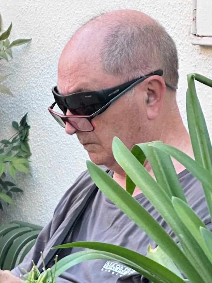 A photographer captures a funny moment of a man wearing two pairs of sunglasses simultaneously.