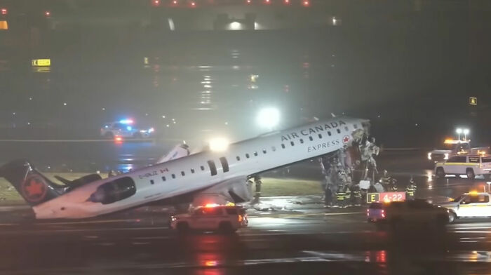 Air Canada crash aftermath with emergency crew and damaged plane on a wet runway at night. Air Canada crash aftermath with emergency crew and damaged plane on a wet runway at night.
