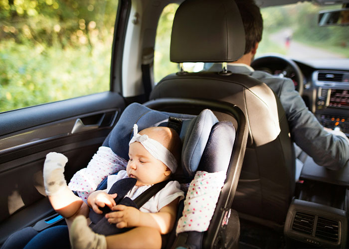 A baby in a car seat, illustrating safety measures parents should never compromise for their children.