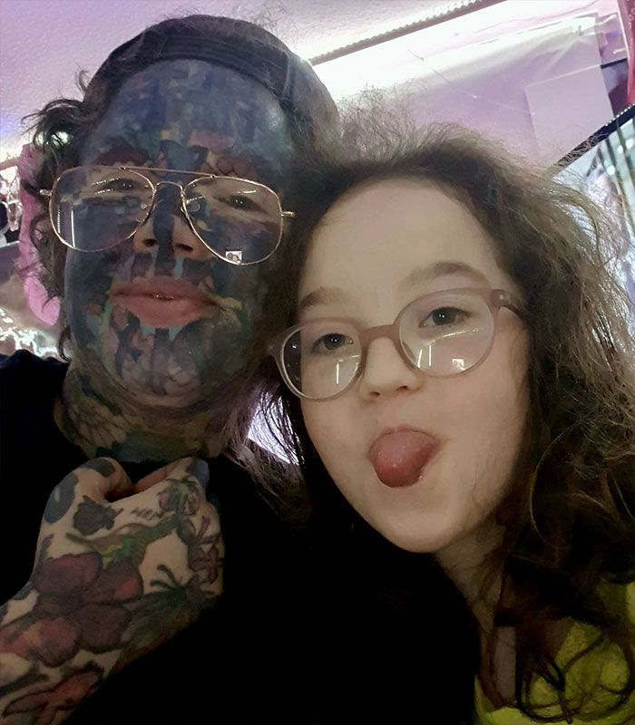 Mom with 800 tattoos, showcasing her extreme face look with her child. Mom with 800 tattoos, showcasing her extreme face look with her child.