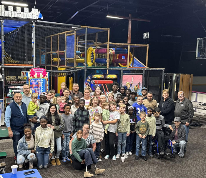 A huge family of 39, including children and adults, gathered in an indoor play area. A huge family of 39, including children and adults, gathered in an indoor play area.