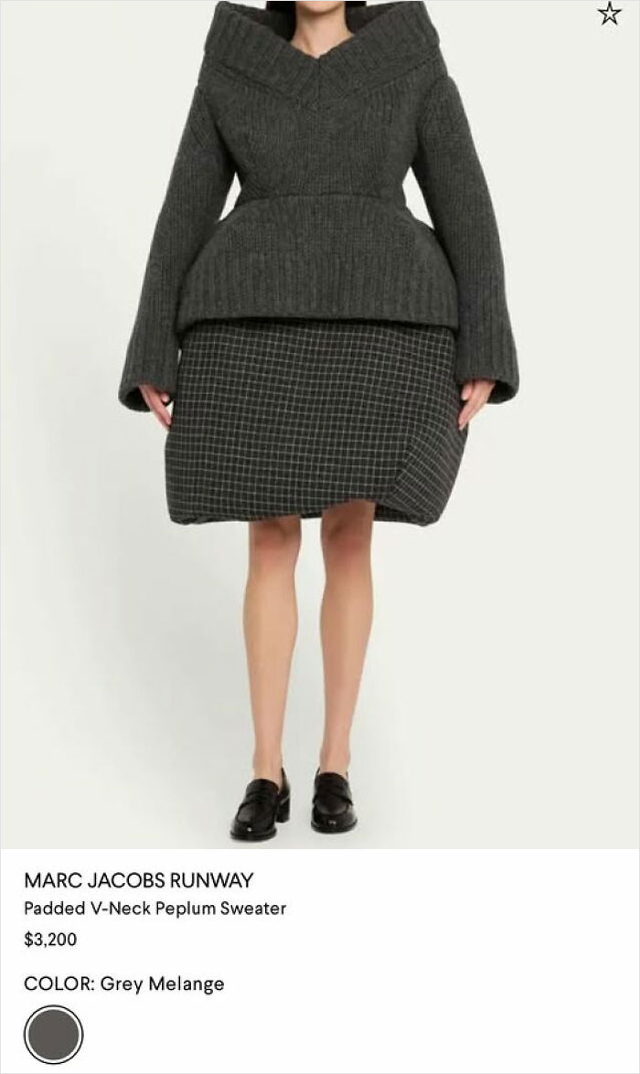 A woman in a grey padded V-neck peplum sweater and a grid-patterned skirt that looks like a hilariously bad fashion statement.