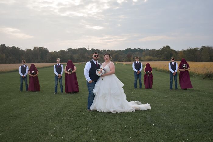 A wedding party posing in a field, creating an iconic and funny wedding photo.