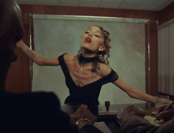 Ariana Grande dramatically posing in a black dress during a music video appearance that stunned fans. Ariana Grande dramatically posing in a black dress during a music video appearance that stunned fans.