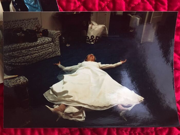 A funny wedding photo of a bride lying on the floor in her dress, capturing an iconic and unexpected moment.
