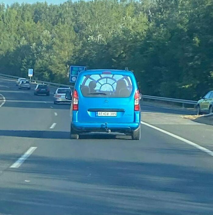 Blue van with an interesting window decal on a road in Eastern Europe, showing people are built different.
