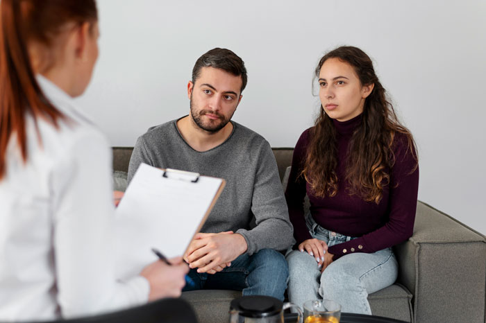 A couple sits attentively with a therapist, discussing MIL issues that might drive the woman to leave her son. A couple sits attentively with a therapist, discussing MIL issues that might drive the woman to leave her son.