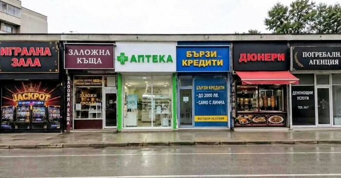 A row of diverse shops including a casino, pawn shop, pharmacy, and fast food, showing Eastern Europe's unique landscape.