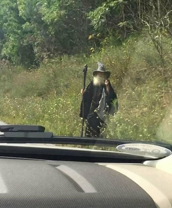 A person dressed as a wizard walking by the road, showing how people from Eastern Europe are built different.