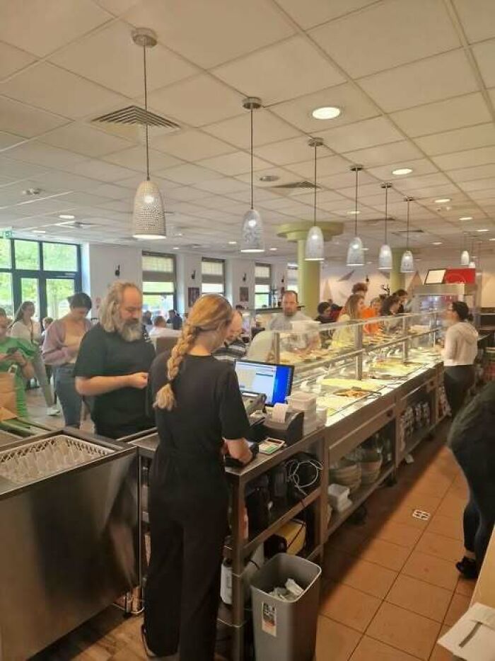 People serving themselves food in a cafeteria, showing how people from Eastern Europe are built different.