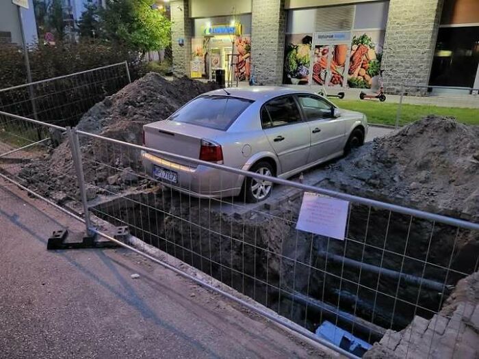 A silver car parked partially in a deep trench, highlighting how people from Eastern Europe are built different.