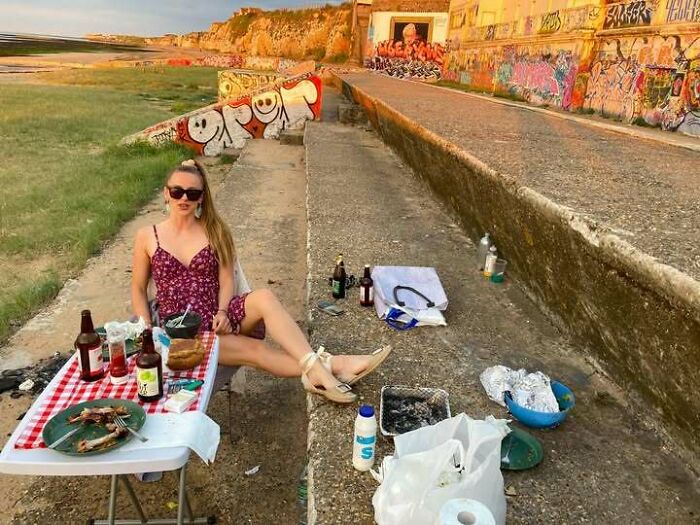 A woman having a picnic on a concrete path with graffiti, illustrating why people from Eastern Europe are built different.