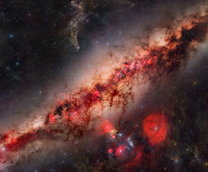 The galactic center of the Milky Way with glowing red nebulae, among the best astronomy photos.