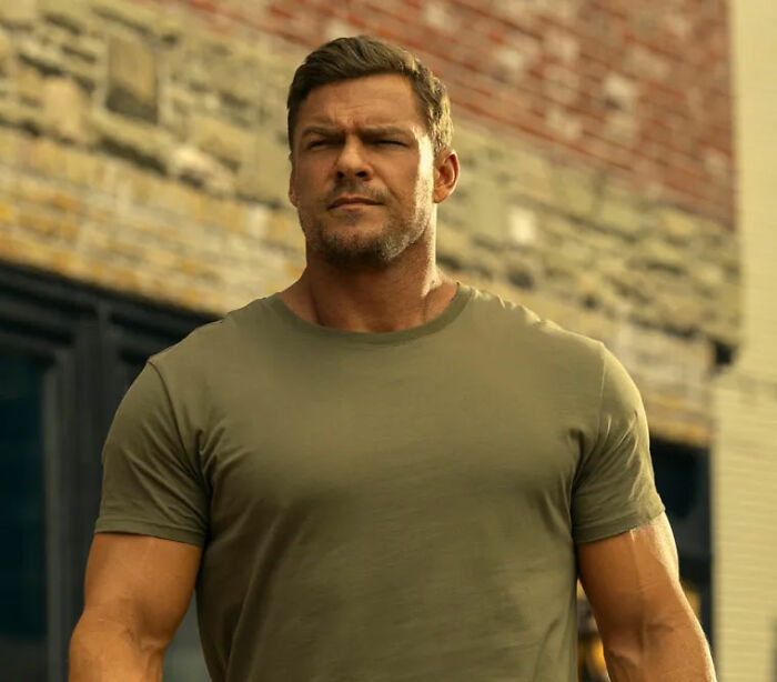Alan Ritchson's shirtless moment in a green t-shirt, showcasing muscular physique outdoors. Alan Ritchson's shirtless moment in a green t-shirt, showcasing muscular physique outdoors.