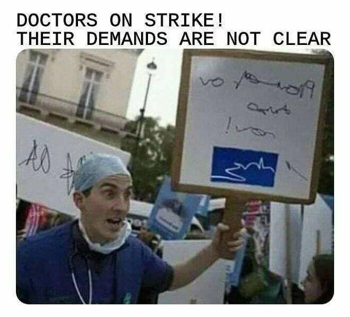 A doctor holding a protest sign with unclear writing, a funny doctor meme about a strike.