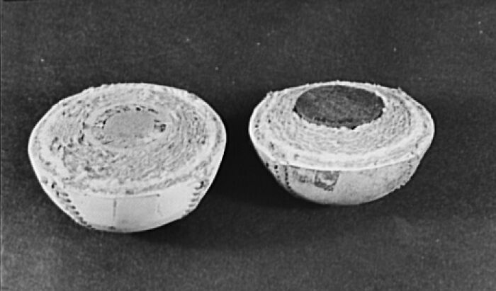 Two baseballs cut in half, showing their tightly wound interiors, an interesting photo of objects cut in half.